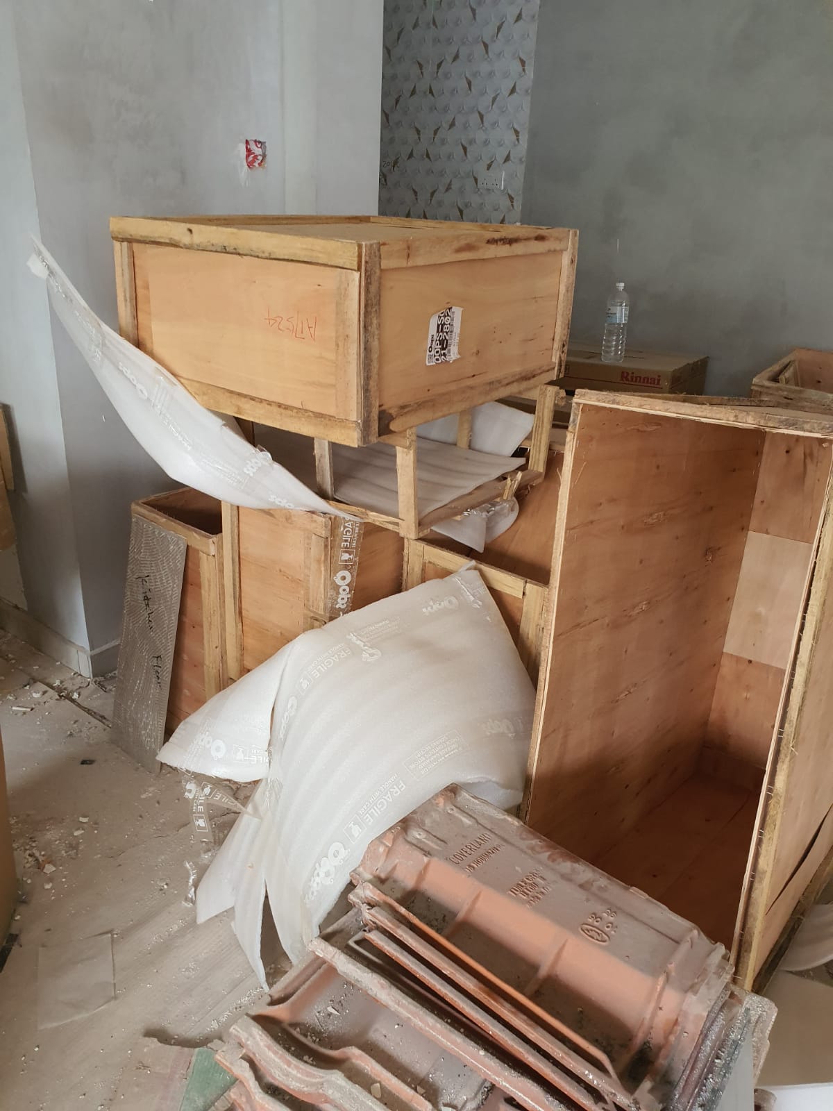 Wooden crates and packing materials stacked in a residential room awaiting removal.