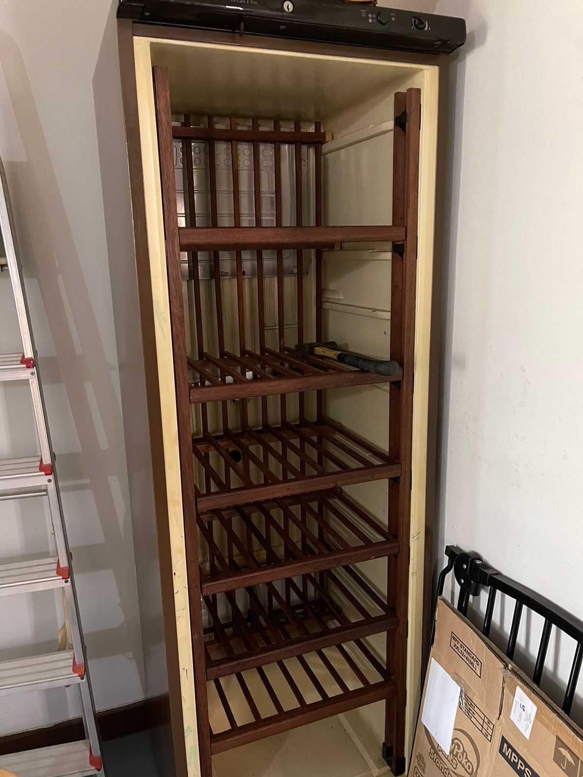 Wooden wine rack with empty shelves, standing upright in a residential space.