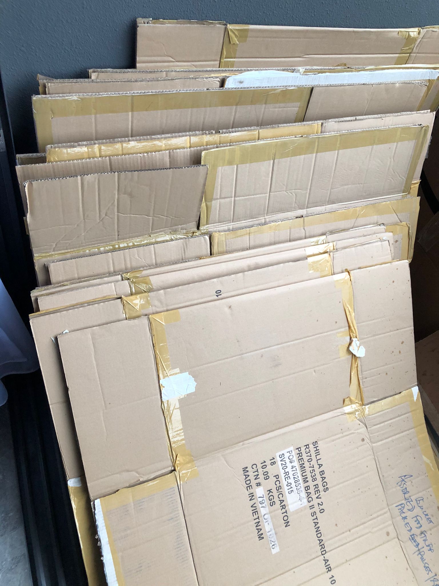 Stack of flattened cardboard boxes bound with tape, ready for collection from a residential home.