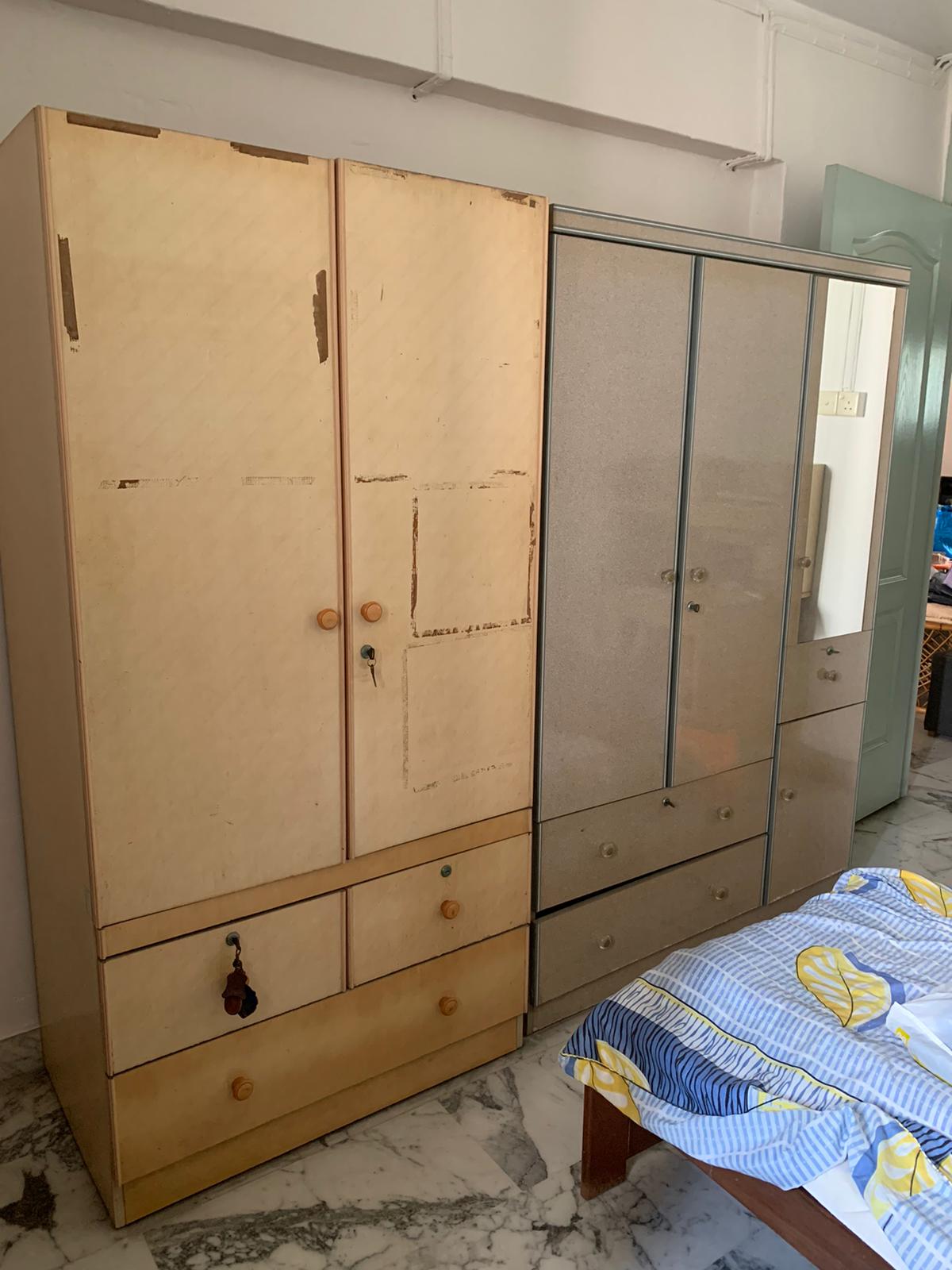 Two wooden wardrobes and a set of drawers on marble flooring in a residential room, ready for disposal.