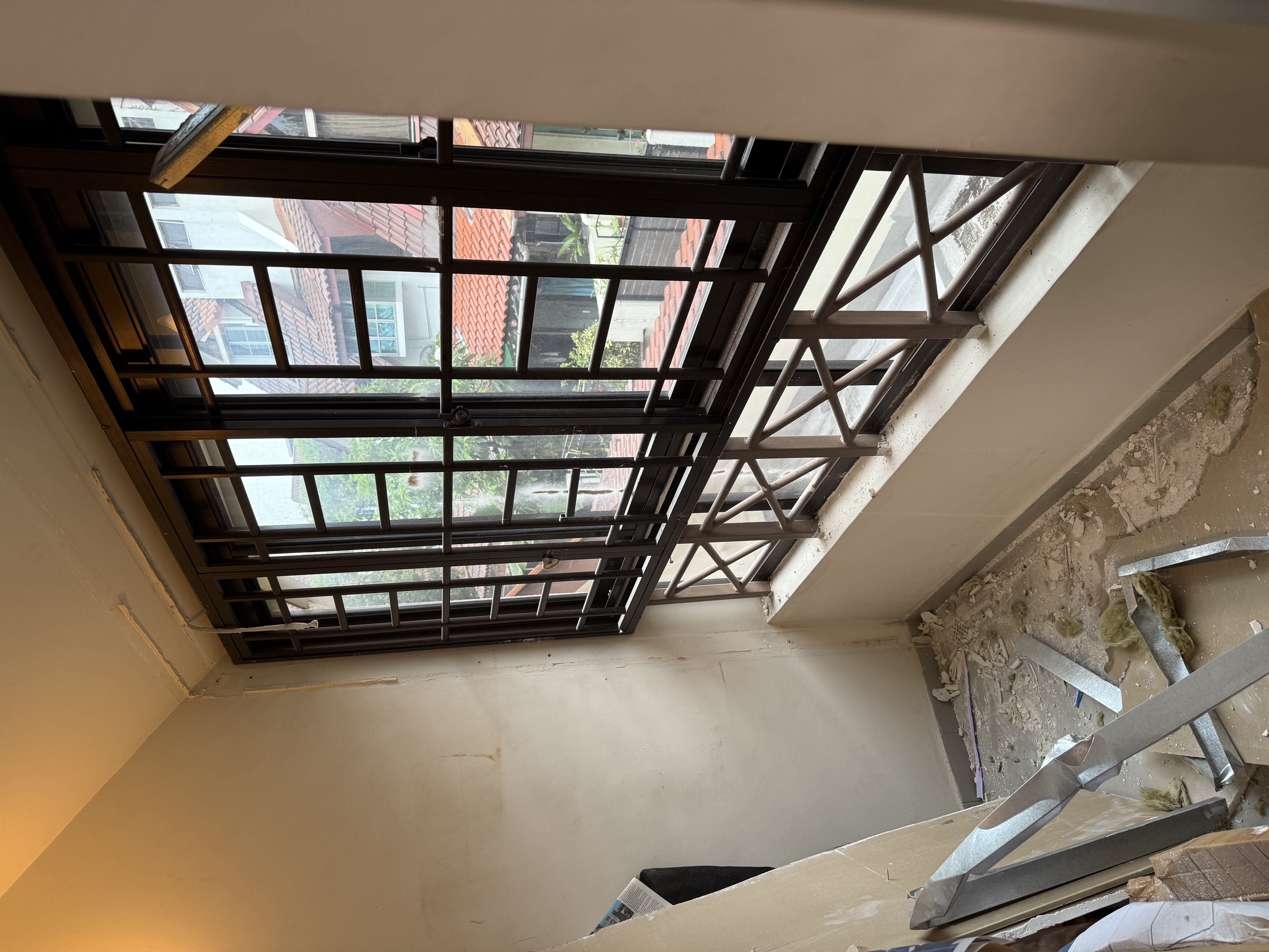 The Pasir Panjang unit immediately after partition demolition — clean floor, last bits of stud-frame metal stacked for removal.
