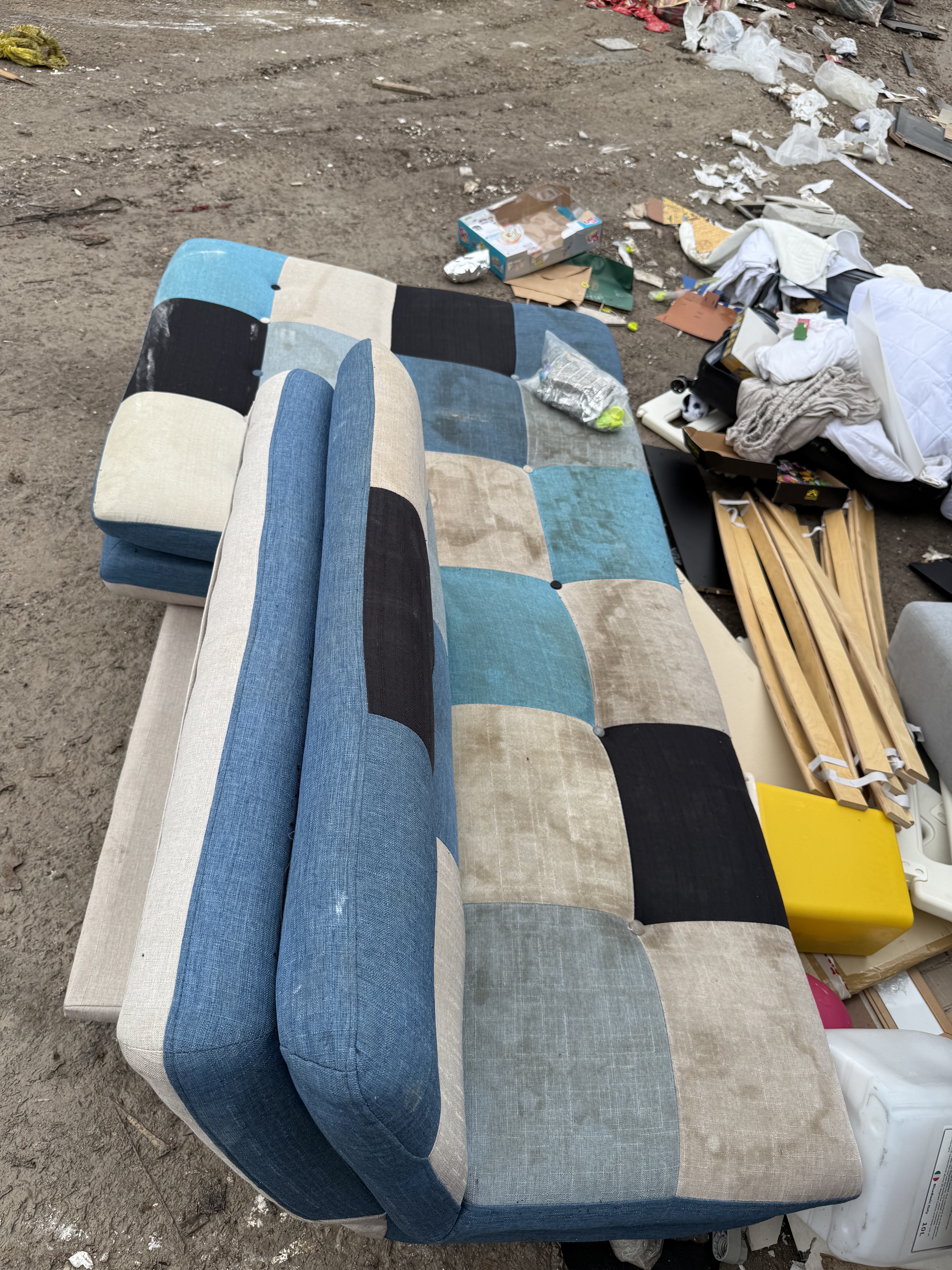 End of the run for this Queenstown sofa bed — patchwork cushions and the timber-shell frame waiting at the yard for material separation.