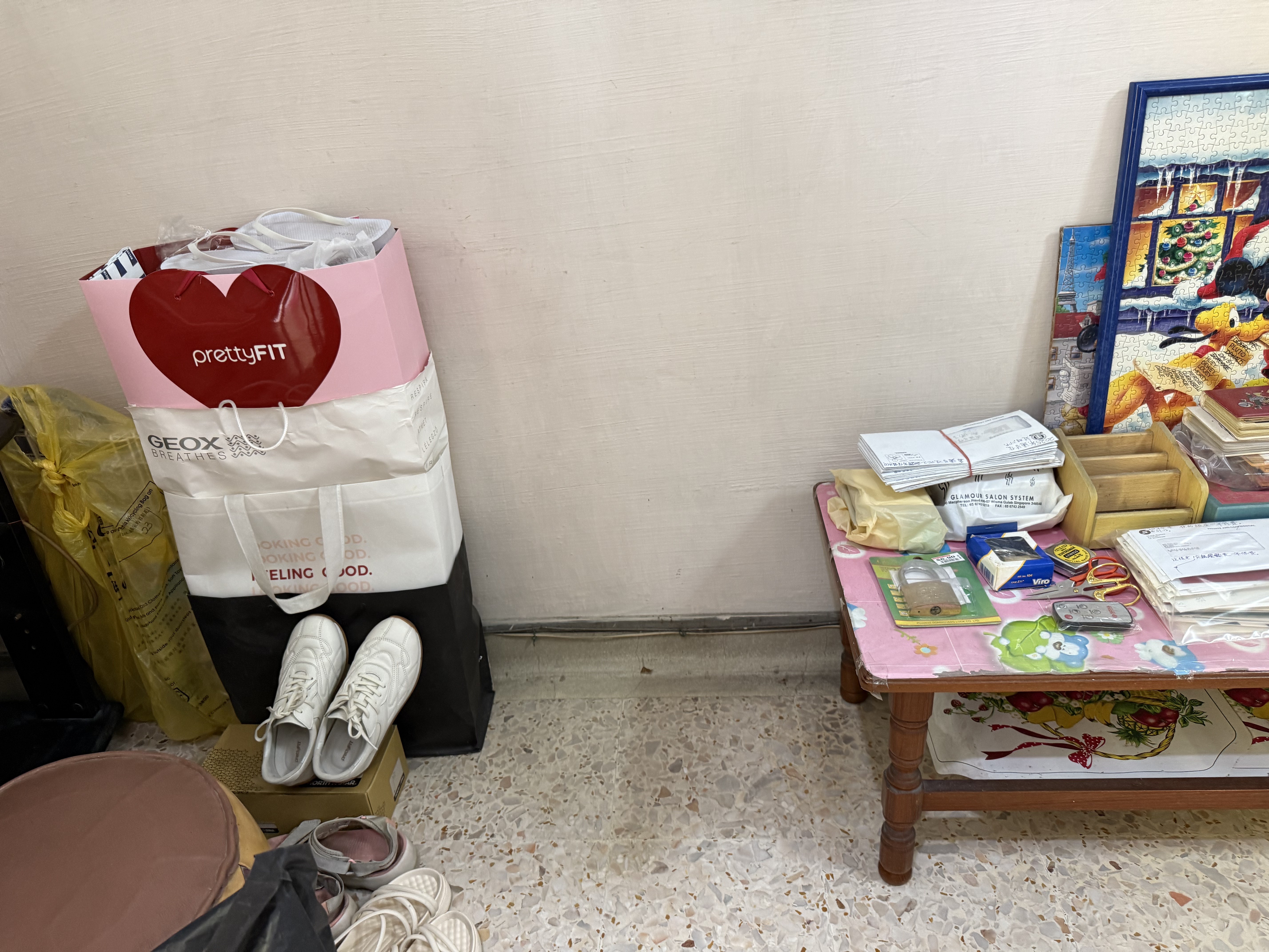 Junk removal in Ang Mo Kio, with stacked shopping bags and shoes next to a table with various items.