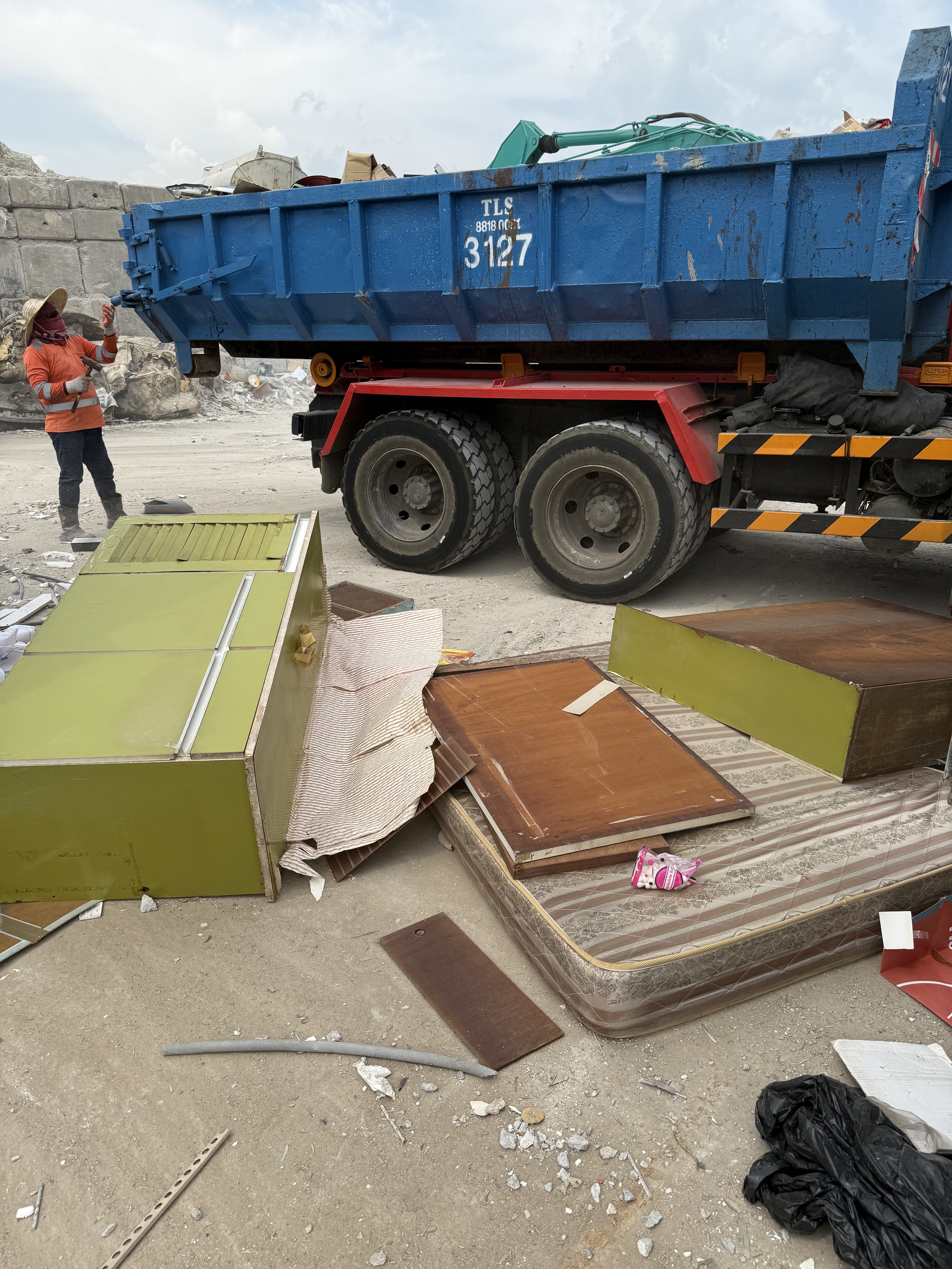 Bulky furniture disposal in Tuas, including a mattress and cabinets next to a disposal truck.