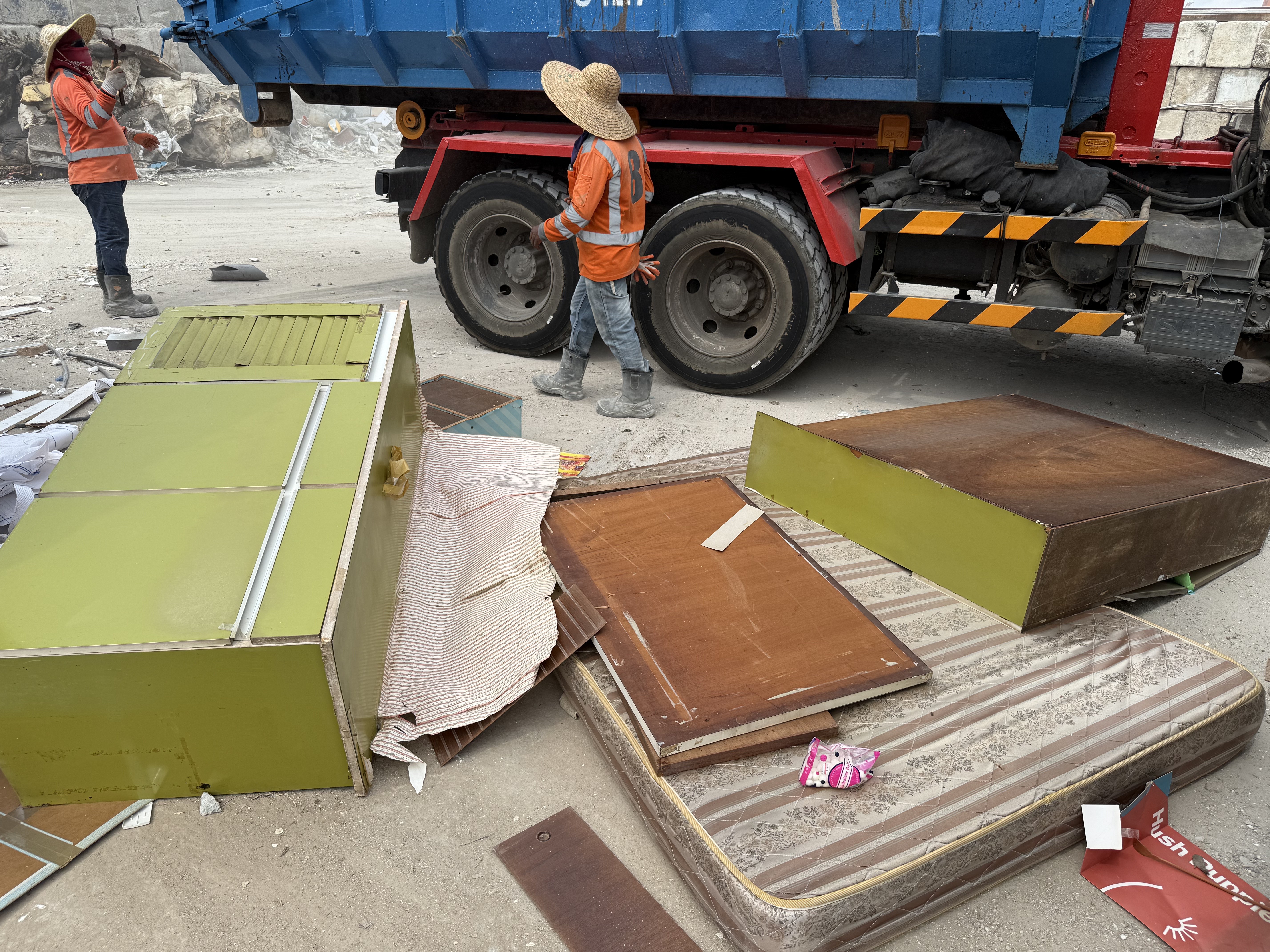The Ang Mo Kio job's load tipped at the sorting yard — green vintage kitchen cabinet panels and old wardrobe doors next to the tipper truck before sorting.